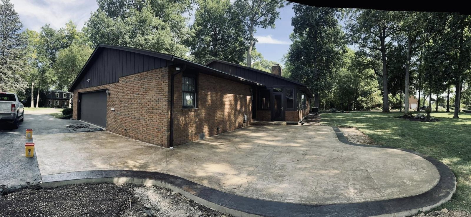 Finished curved stamped concrete driveway at a brick ranch home